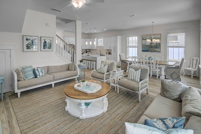 living room with ceiling fan, sink, and light hardwood / wood-style flooring