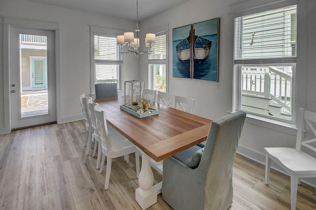 dining room featuring a notable chandelier, light hardwood / wood-style flooring, and a healthy amount of sunlight