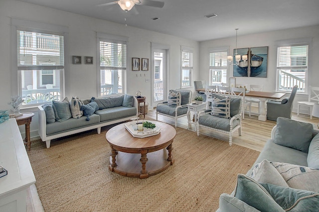 living room featuring ceiling fan, light wood-type flooring, and a healthy amount of sunlight