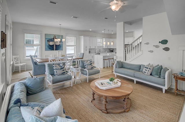 living room featuring light hardwood / wood-style floors, ceiling fan, and a healthy amount of sunlight