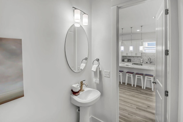 bathroom featuring tasteful backsplash and hardwood / wood-style floors