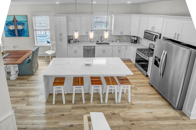 kitchen featuring stainless steel appliances, plenty of natural light, and a kitchen island