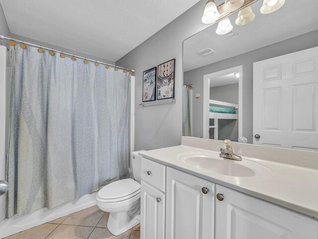 bathroom featuring a textured ceiling, toilet, vanity, and tile patterned floors