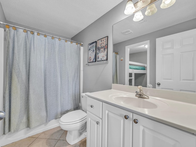 bathroom featuring visible vents, toilet, a textured ceiling, vanity, and tile patterned floors