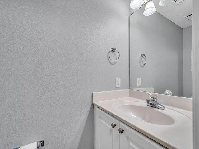 bathroom with a textured ceiling and vanity