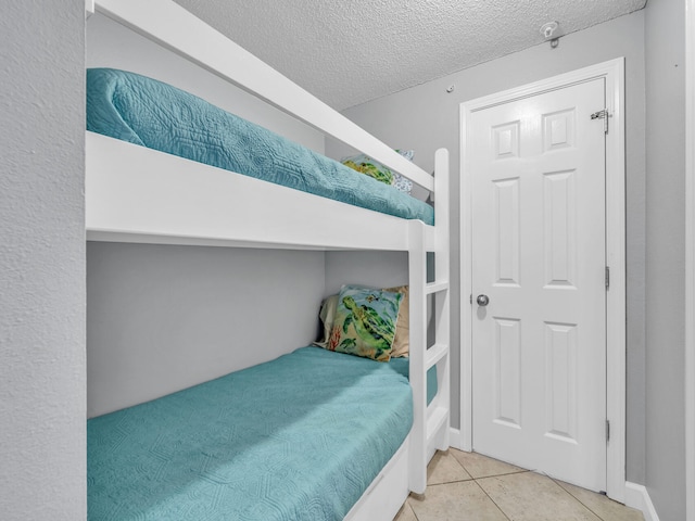 tiled bedroom with a textured ceiling