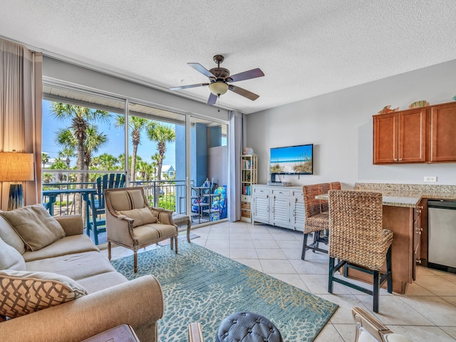 living room featuring a ceiling fan, a textured ceiling, and light tile patterned floors