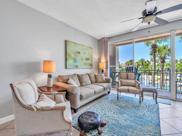 living room featuring ceiling fan, a textured ceiling, and light tile patterned floors