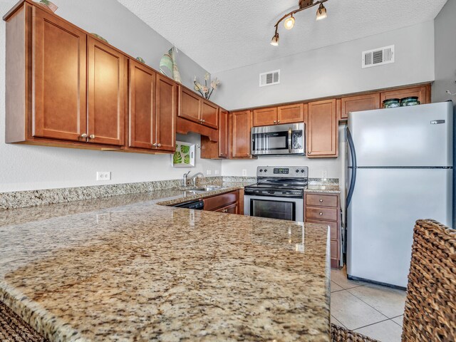 kitchen featuring appliances with stainless steel finishes, a textured ceiling, track lighting, and kitchen peninsula