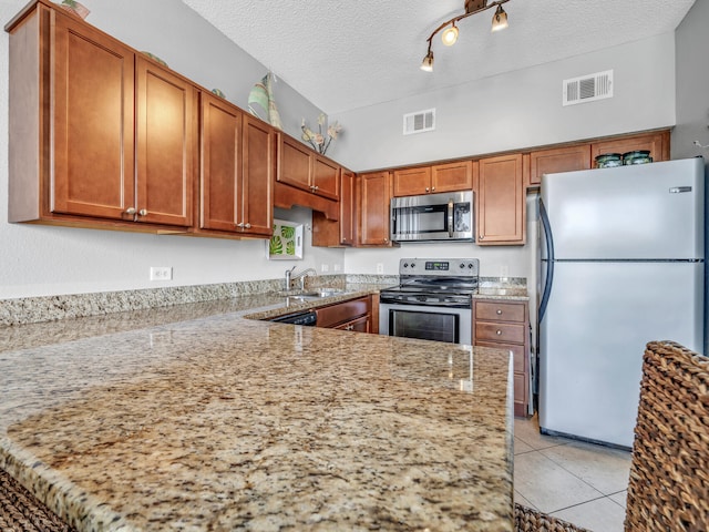 kitchen featuring appliances with stainless steel finishes, brown cabinets, visible vents, and light tile patterned floors