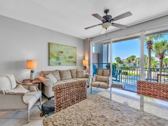 living room featuring ceiling fan, a textured ceiling, and light tile patterned floors