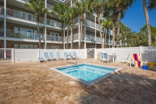 view of pool with a hot tub and a patio