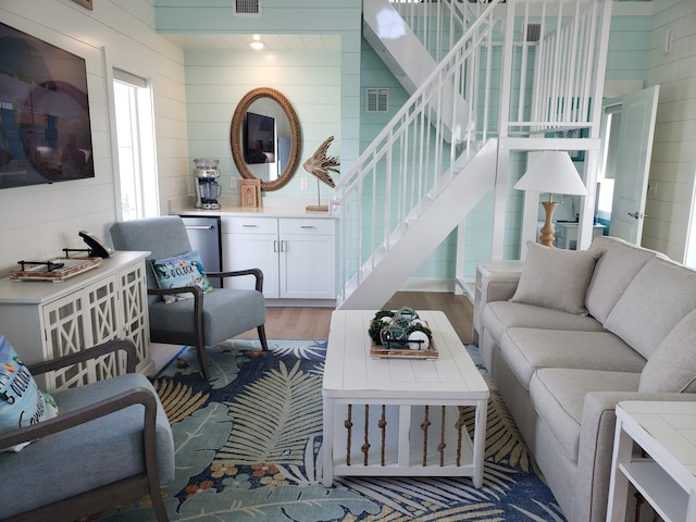 living room with hardwood / wood-style flooring and wooden walls