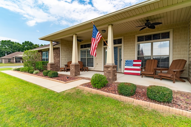 view of front of house featuring ceiling fan, covered porch, and a front lawn