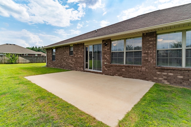 back of property featuring a patio area and a yard