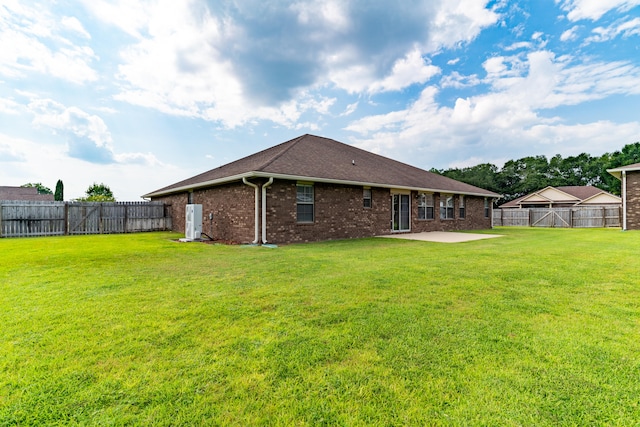 rear view of house with a patio and a yard