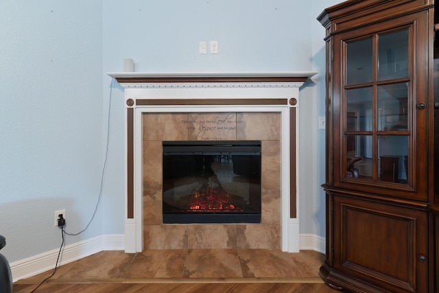 details with hardwood / wood-style floors and a tile fireplace