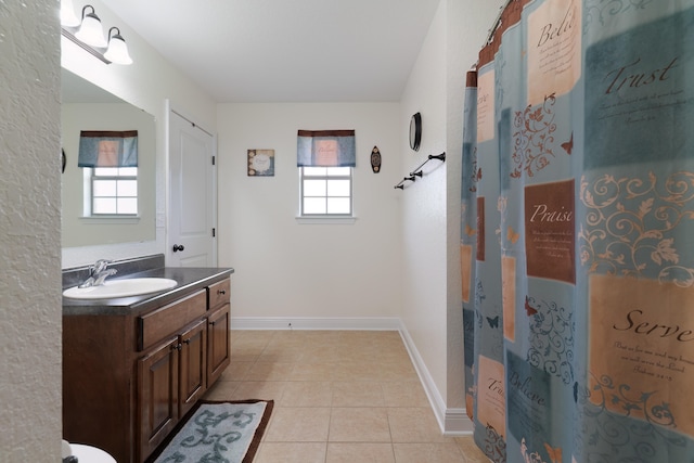 bathroom featuring a wealth of natural light, tile patterned flooring, and vanity