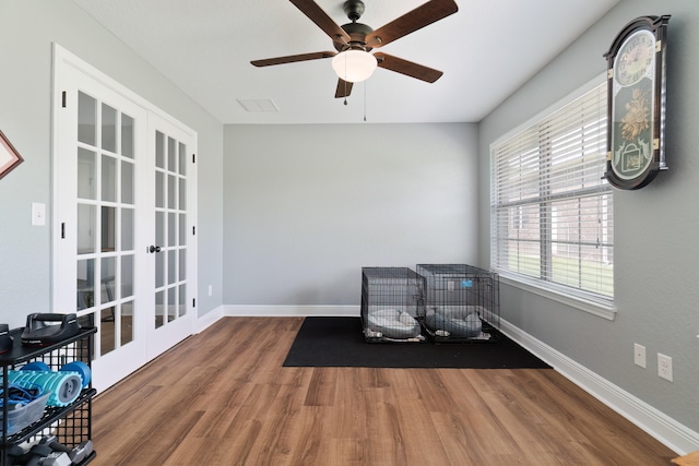 unfurnished room with ceiling fan, french doors, and wood-type flooring