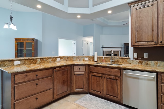 kitchen with stainless steel dishwasher, a tray ceiling, light stone countertops, sink, and kitchen peninsula