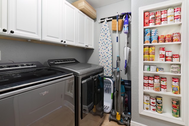 laundry room with washer and clothes dryer, tile patterned floors, and cabinets