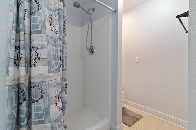 bathroom with tile patterned flooring, toilet, and walk in shower