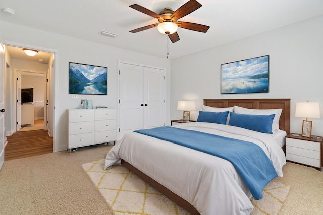 bedroom with light colored carpet, a closet, and ceiling fan