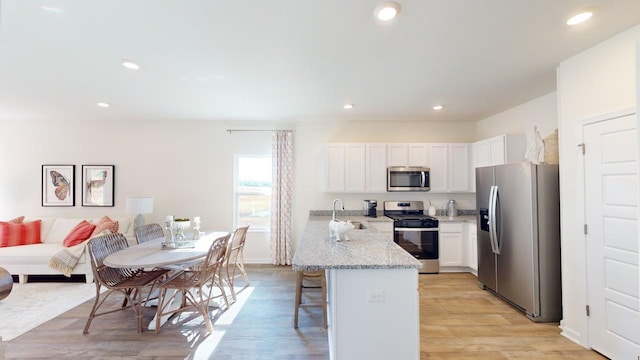 kitchen featuring light stone countertops, sink, white cabinets, and appliances with stainless steel finishes