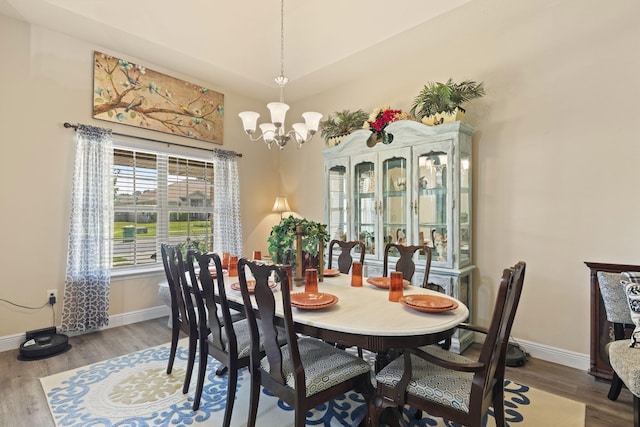 dining space featuring hardwood / wood-style flooring and a notable chandelier