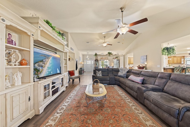 living room with ceiling fan, vaulted ceiling, dark wood-type flooring, and plenty of natural light