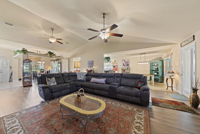 living room featuring ceiling fan, lofted ceiling, and wood-type flooring