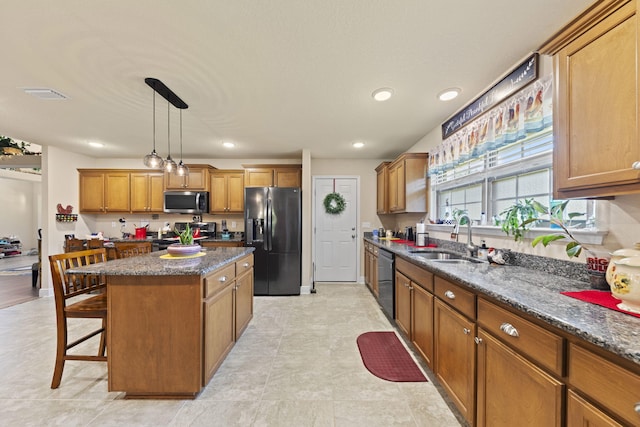 kitchen featuring sink, a breakfast bar, light tile patterned flooring, and black appliances