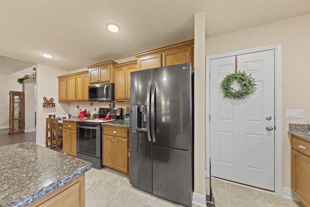 kitchen featuring black fridge with ice dispenser, light tile patterned floors, dark stone countertops, and electric range oven