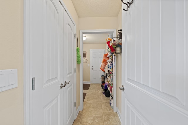 interior space with a textured ceiling and light tile patterned floors