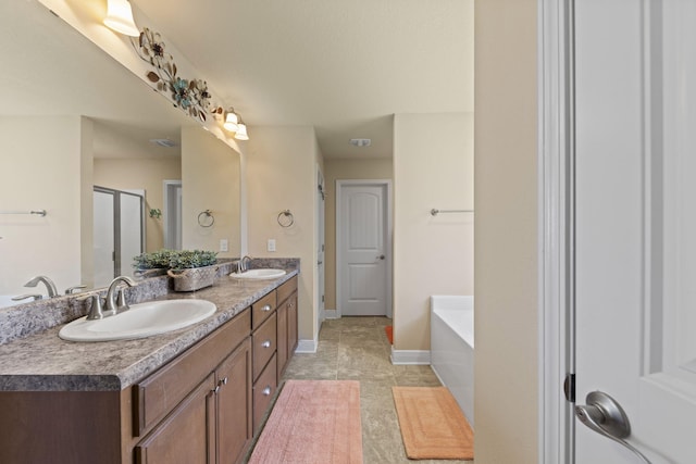 bathroom with double sink vanity, tile patterned floors, and a tub to relax in