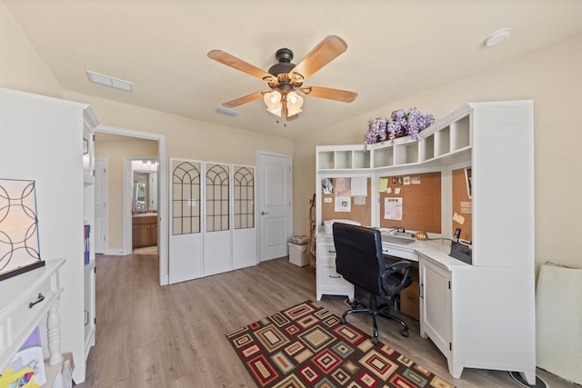 home office with light hardwood / wood-style flooring and ceiling fan