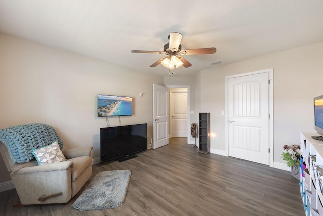 living room featuring ceiling fan and dark hardwood / wood-style floors