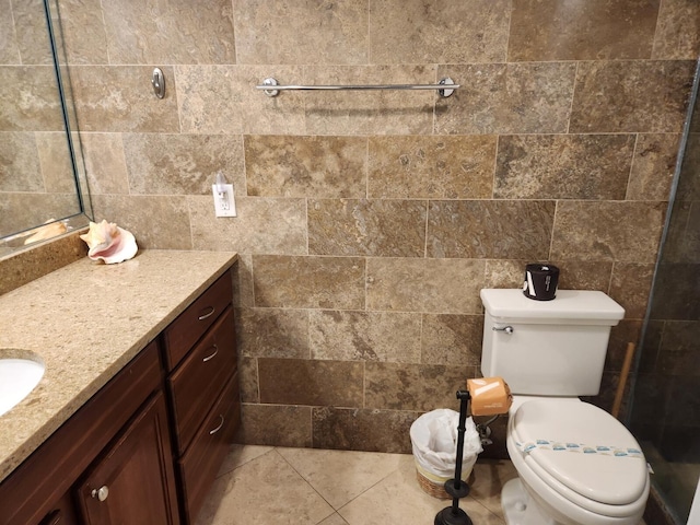 bathroom featuring tile patterned floors, tile walls, vanity, and toilet