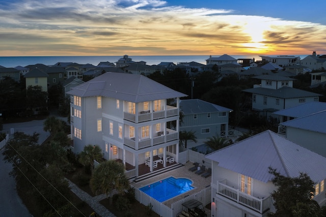 aerial view at dusk featuring a water view