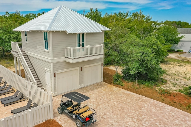 view of side of property with a garage and a balcony