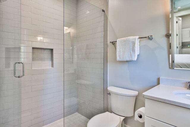 bathroom featuring toilet, a shower with door, and vanity