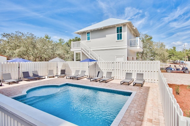 rear view of house featuring a patio and a fenced in pool