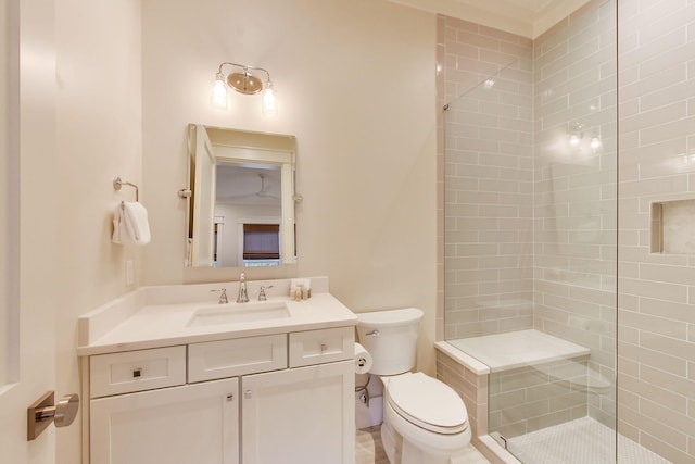 bathroom with vanity, tiled shower, and toilet