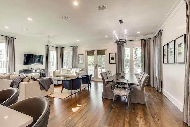 dining space with crown molding, french doors, dark wood-type flooring, and a chandelier