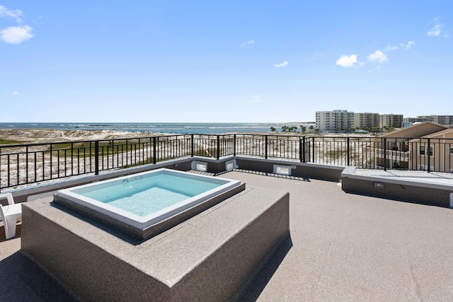 view of swimming pool featuring an in ground hot tub and a water view