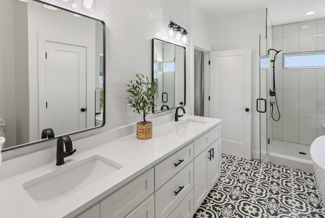 bathroom with a shower with door, vanity, and tile patterned flooring