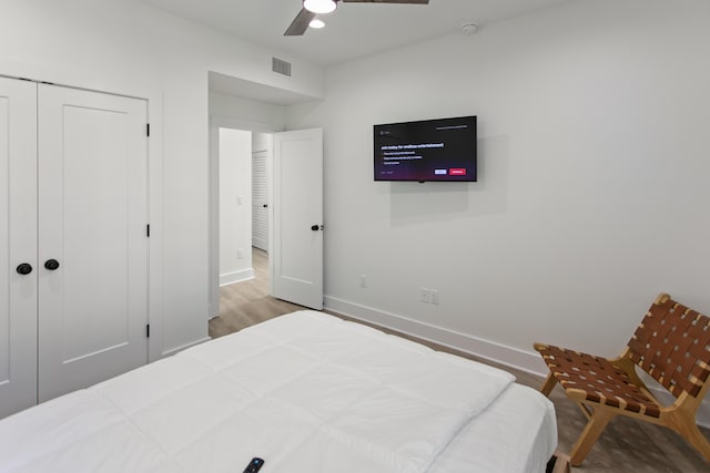 bedroom featuring ceiling fan, light hardwood / wood-style floors, and a closet