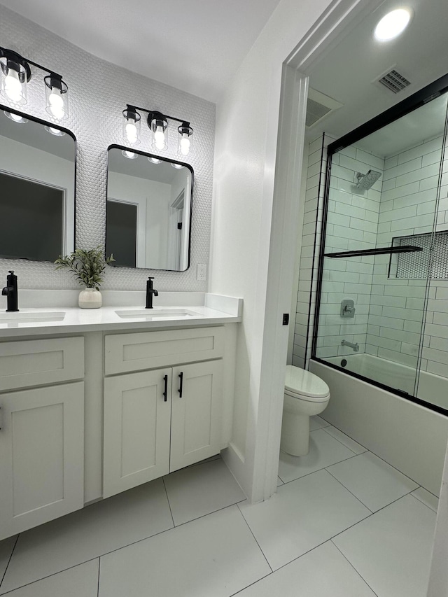 full bathroom with tile patterned flooring, enclosed tub / shower combo, vanity, and toilet