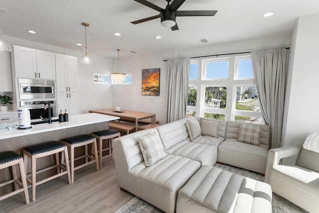 living room featuring ceiling fan and light wood-type flooring