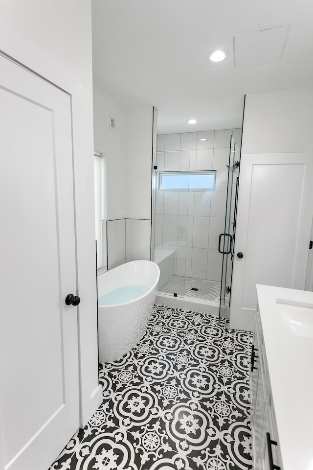 bathroom featuring tile patterned flooring, vanity, and separate shower and tub